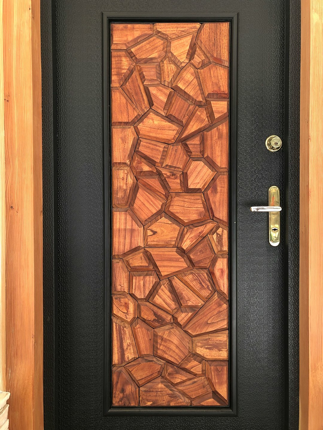 Moderne Holz- und Metall-Haustür mit Messingbeschlägen.